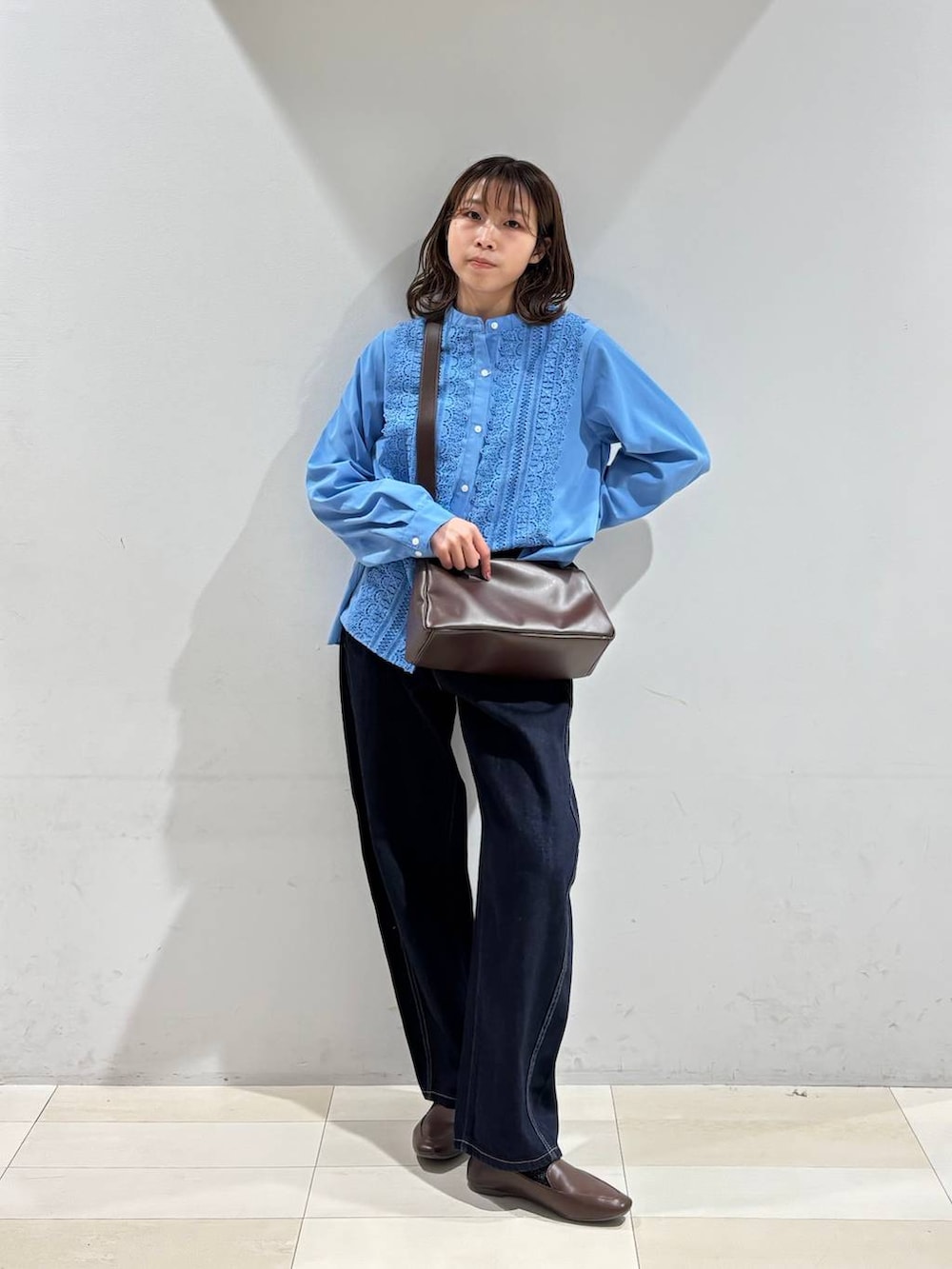 ブルー系のデニムパンツ、ブラウン系のショルダーバッグ、ブルー系のシャツ/ブラウスを着用したレディースの春コーディネートの8枚目の写真