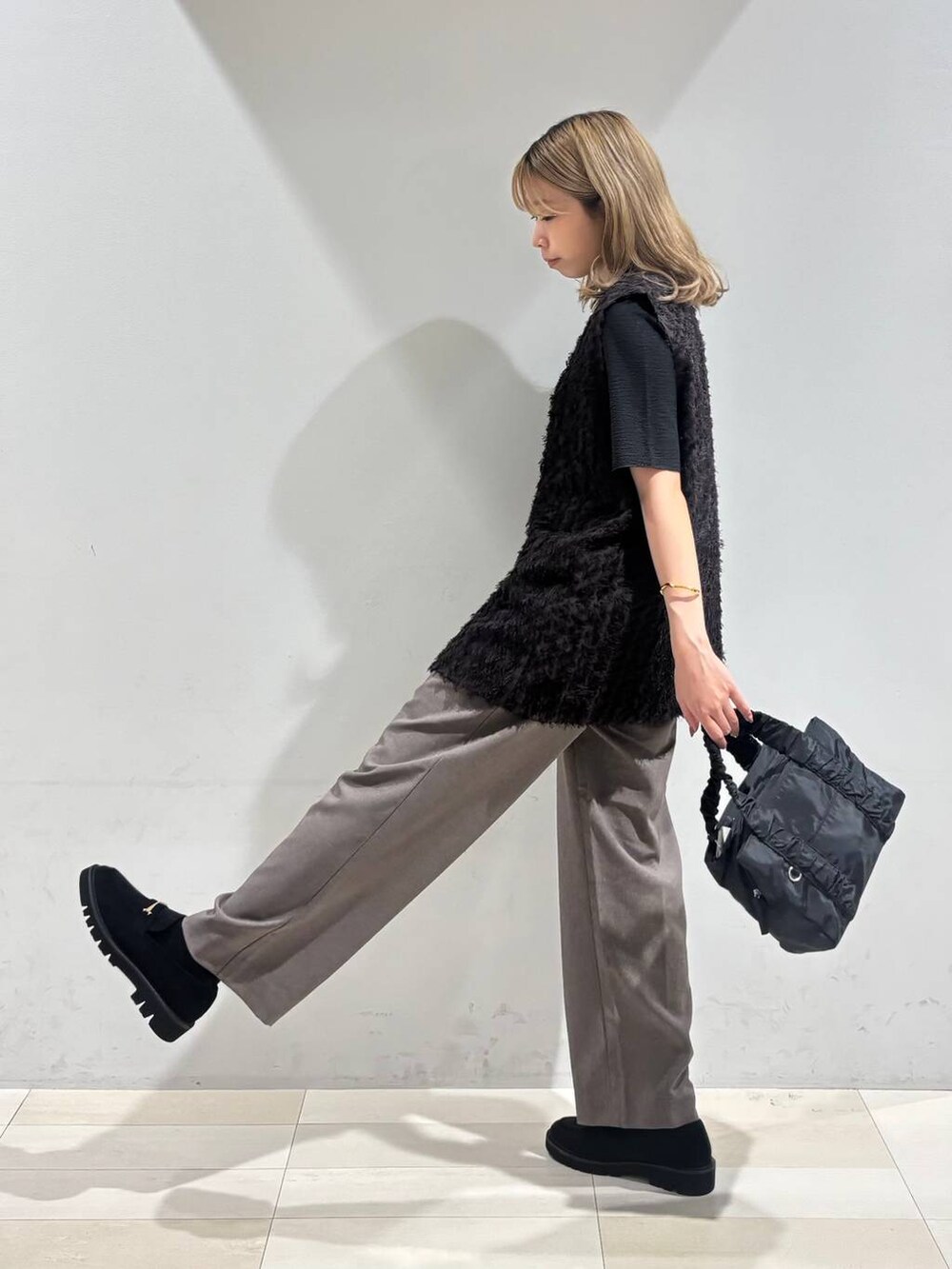 ブラック系のショルダーバッグ、ブラック系のTシャツ/カットソー、ブラック系のローファーを着用したレディースの秋コーディネートの5枚目の写真