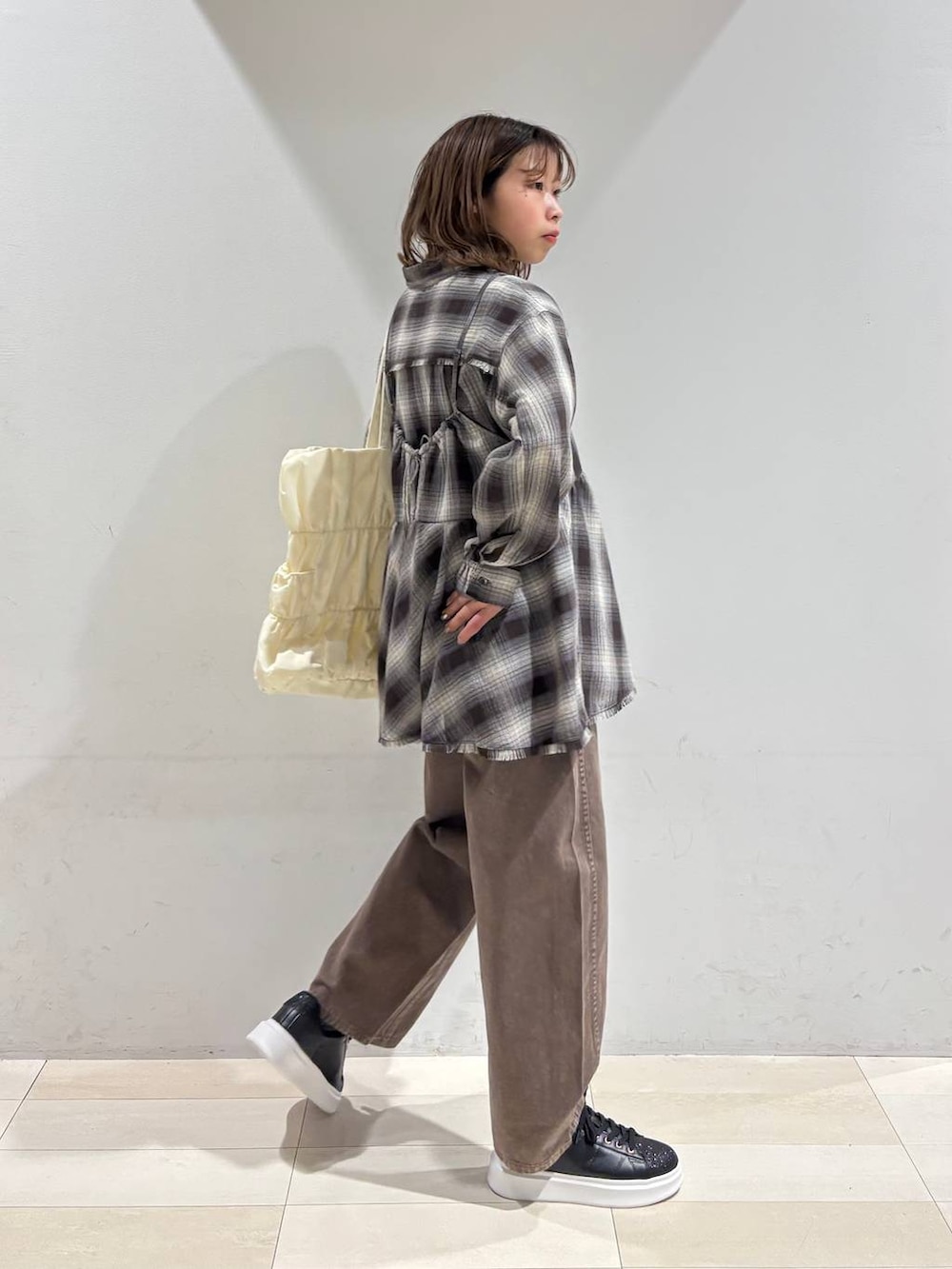 ベージュ系のトートバッグ、ブラウン系のデニムパンツ、ブラウン系のシャツ/ブラウスを着用したレディースの春コーディネートの7枚目の写真