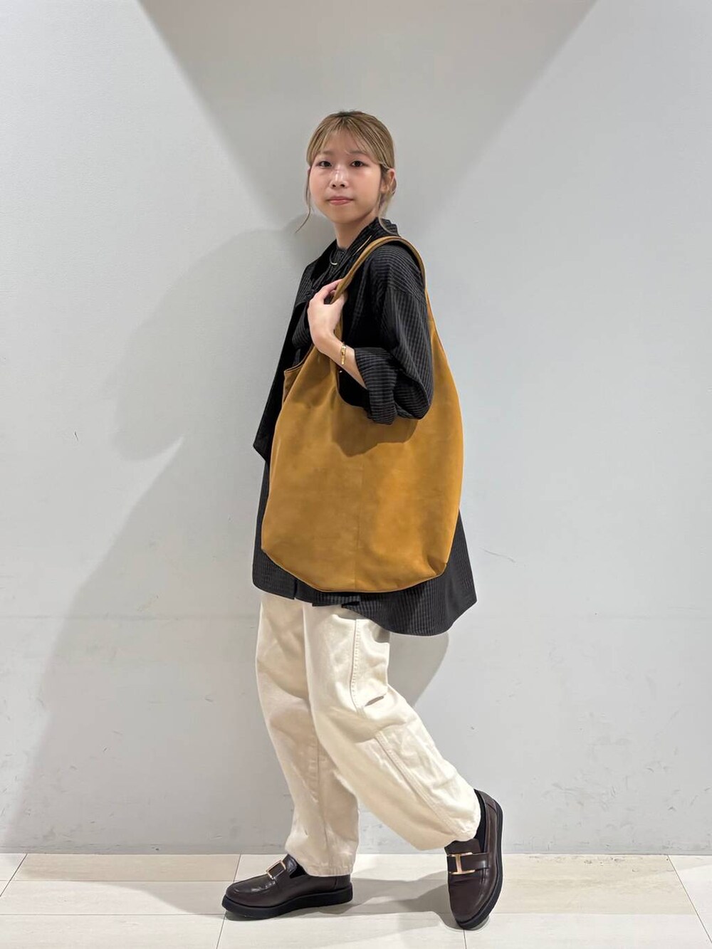 ベージュ系のデニムパンツ、ブラウン系のローファー、イエロー系のトートバッグを着用したレディースの夏コーディネートの3枚目の写真