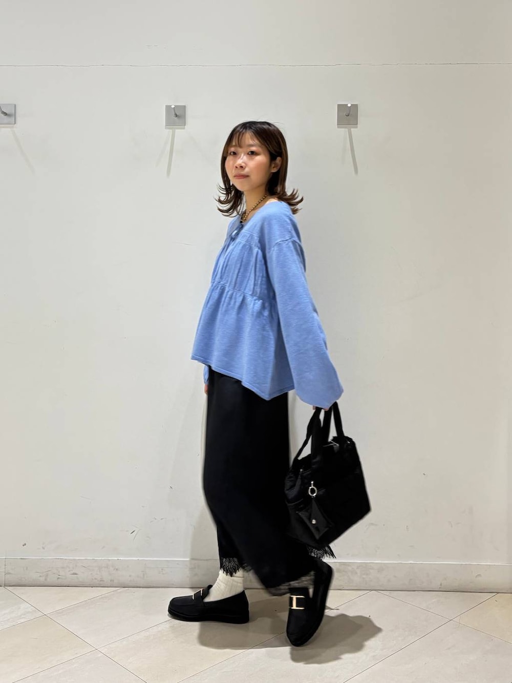 ブラック系のローファー、ブラック系のトートバッグ、ブルー系のカーディガン/ボレロを着用したレディースの春コーディネートの4枚目の写真