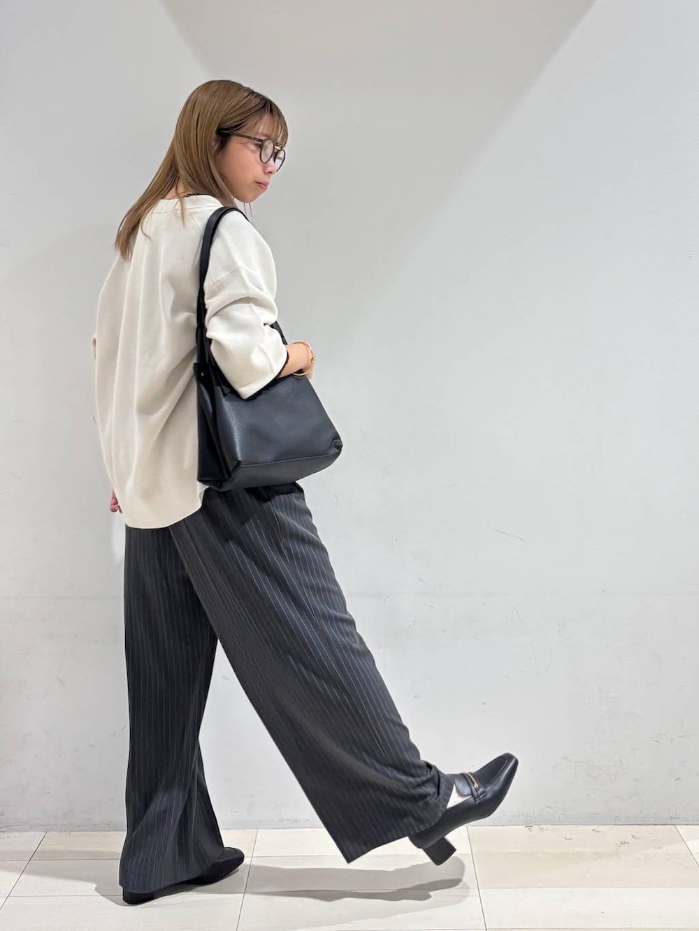 ブラック系のTシャツ/カットソー、グレー系のその他パンツ、ブラック系のトートバッグを着用したレディースの秋コーディネートの6枚目の写真