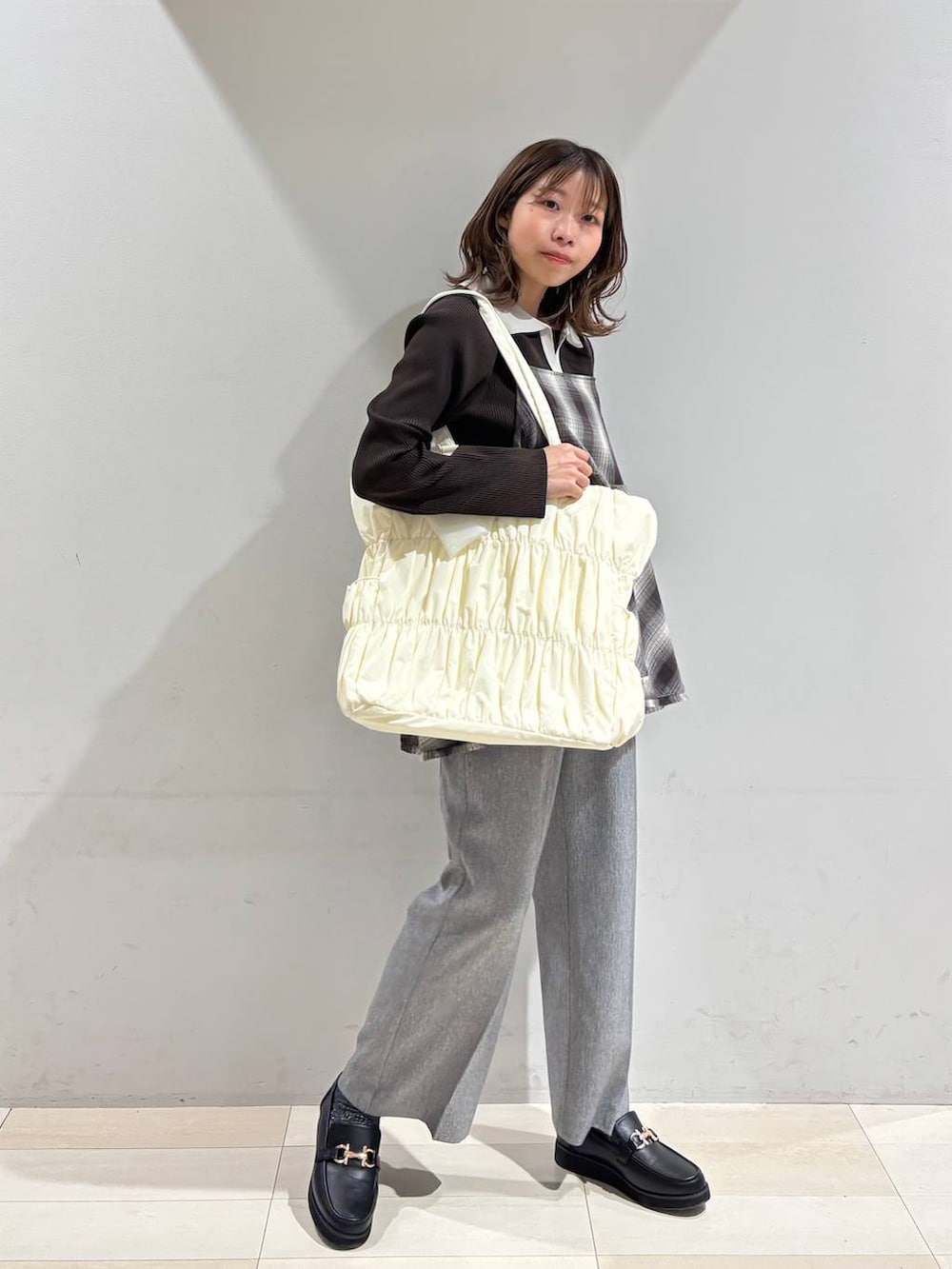 ブラック系のローファー、ベージュ系のトートバッグ、グレー系のその他パンツを着用したレディースの春コーディネートの3枚目の写真