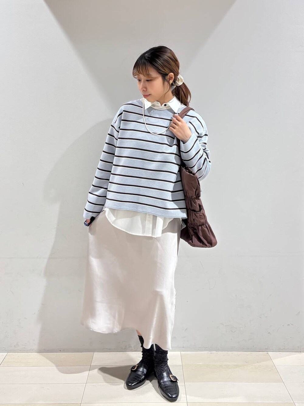 ブラック系のローファー、ブラウン系のトートバッグ、ブルー系のニット/セーターを着用したレディースの冬コーディネートの8枚目の写真