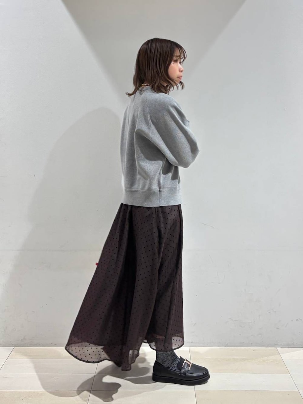 ブラック系のローファー、ホワイト系のハンドバッグ、ブラウン系のスカートを着用したレディースの春コーディネートの6枚目の写真