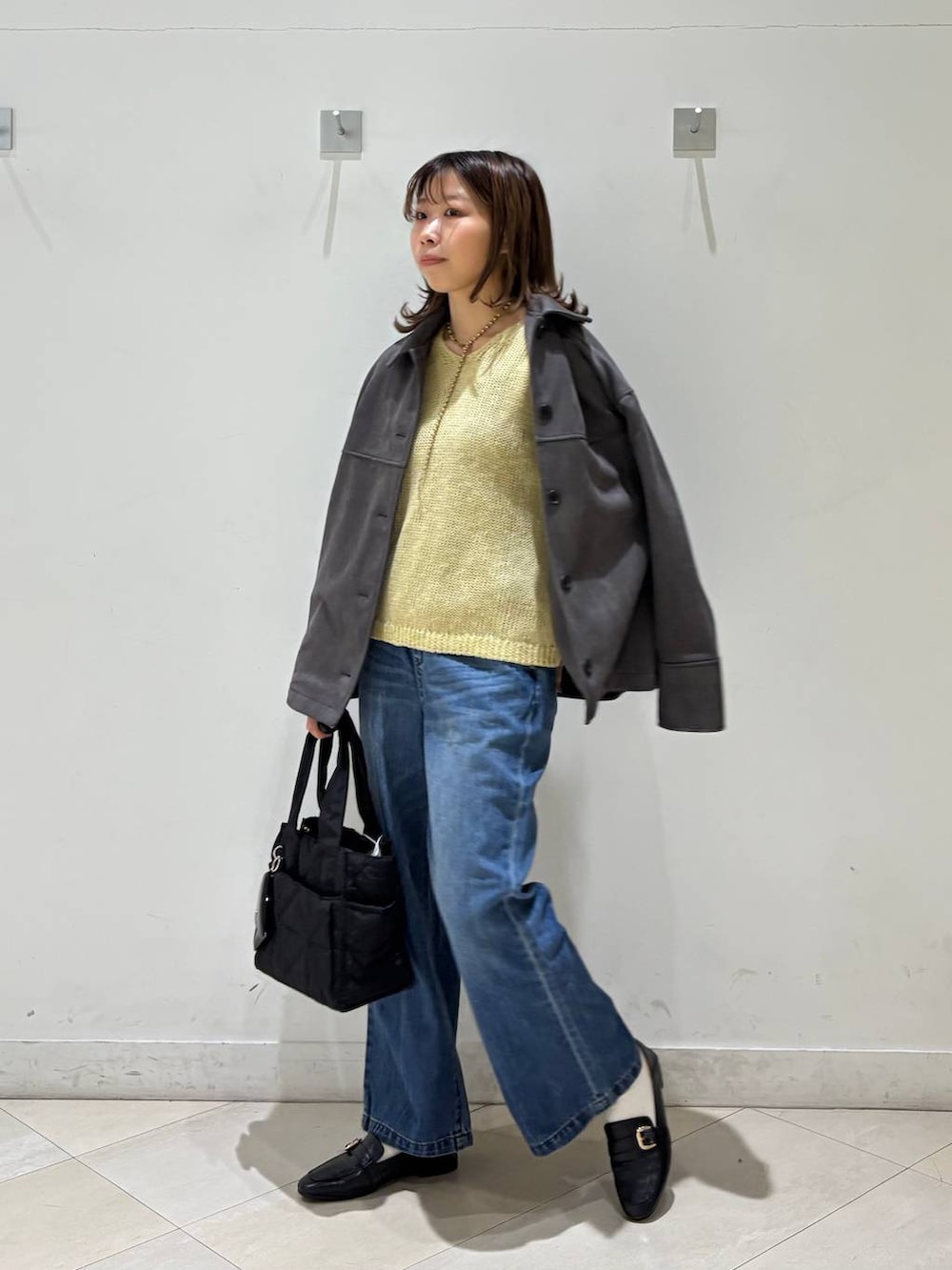 ブラック系のローファー、ブラック系のトートバッグ、ブルー系のデニムパンツを着用したレディースの春コーディネートの9枚目の写真