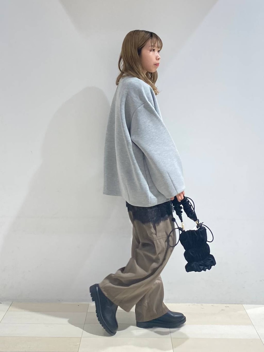 グリーン系のその他パンツ、ブラック系のブーツ、ホワイト系のキャミソールを着用したレディースの秋コーディネートの4枚目の写真