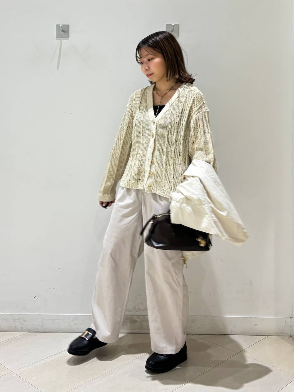 ブラック系のローファー、ブラック系のキャミソール、ブラウン系のボストンバッグを着用したレディースの春コーディネートの3枚目の写真