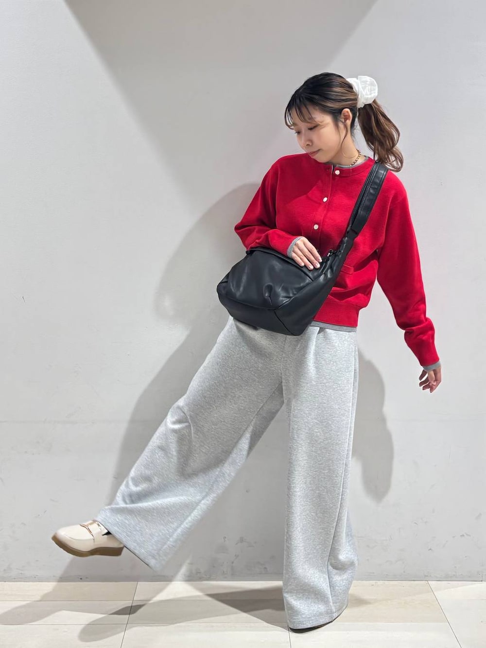 ホワイト系のローファー、ブラック系のショルダーバッグ、グレー系のスウェットパンツを着用したレディースの冬コーディネートの6枚目の写真