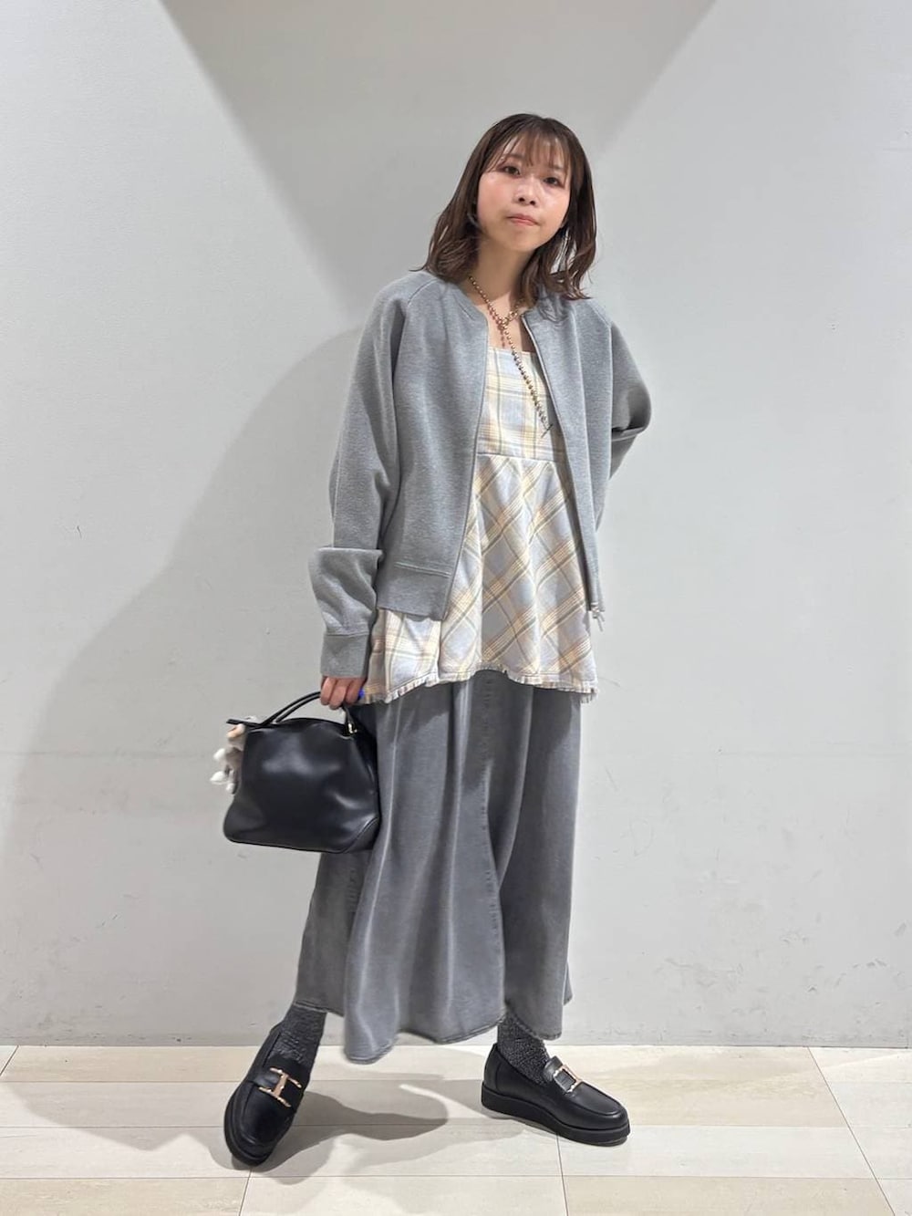 ブラック系のショルダーバッグ、ブラック系のローファー、ブルー系のその他トップスを着用したレディースの春コーディネートの2枚目の写真