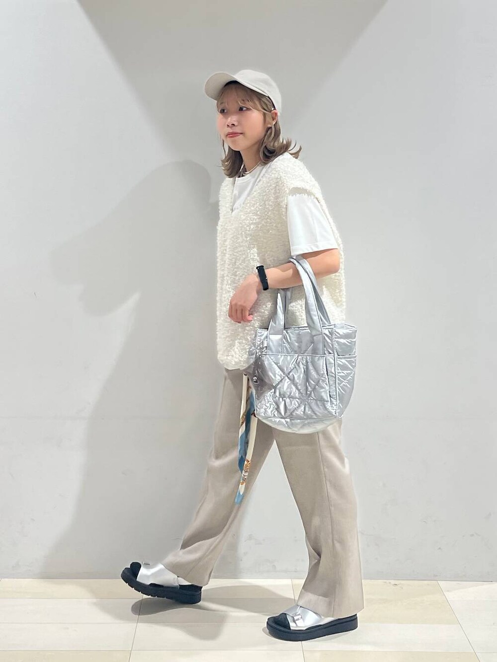 シルバー系のトートバッグ、シルバー系のサンダル、ベージュ系のその他パンツを着用したレディースの夏コーディネートの2枚目の写真