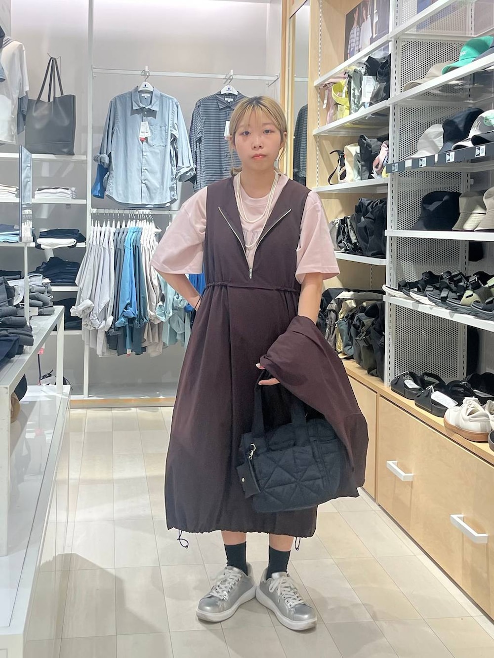 シルバー系のスニーカー、ブラック系のトートバッグ、ピンク系のTシャツ/カットソーを着用したレディースの夏コーディネートの2枚目の写真
