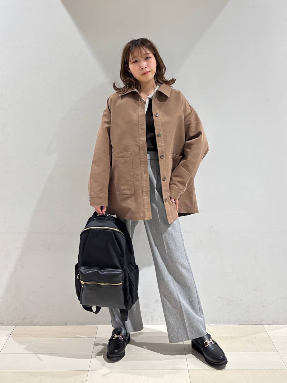 ブラック系のローファー、ブラック系のバックパック/リュック、グレー系のその他パンツを着用したレディースの春コーディネートの2枚目の写真