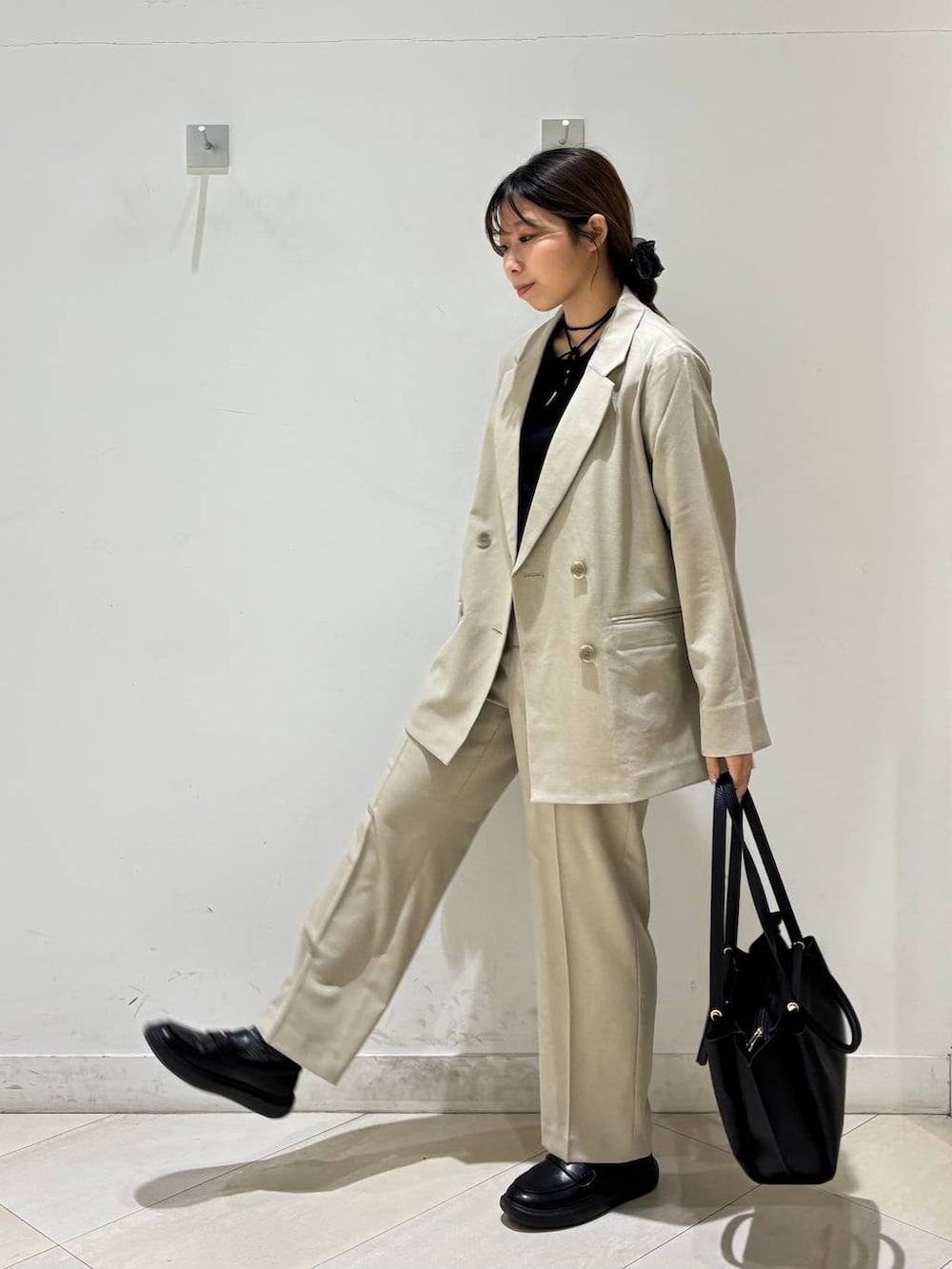 ベージュ系のその他パンツ、ベージュ系のテーラードジャケット、ブラック系のトートバッグを着用したレディースの春コーディネートの2枚目の写真
