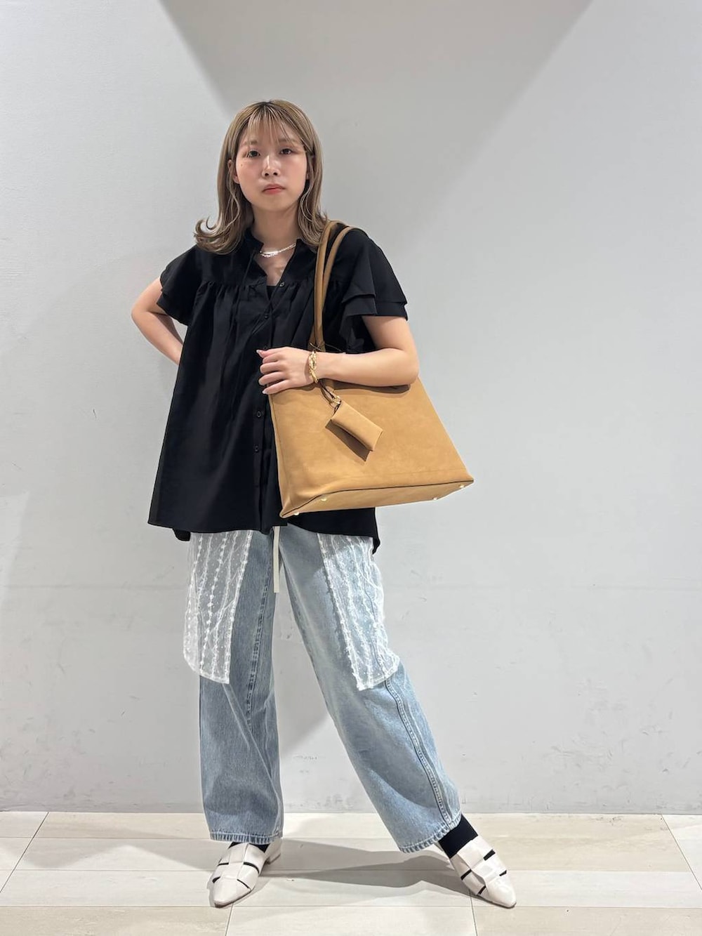 ブルー系のデニムパンツ、ホワイト系のパンプス、ベージュ系のトートバッグを着用したレディースの夏コーディネートの8枚目の写真