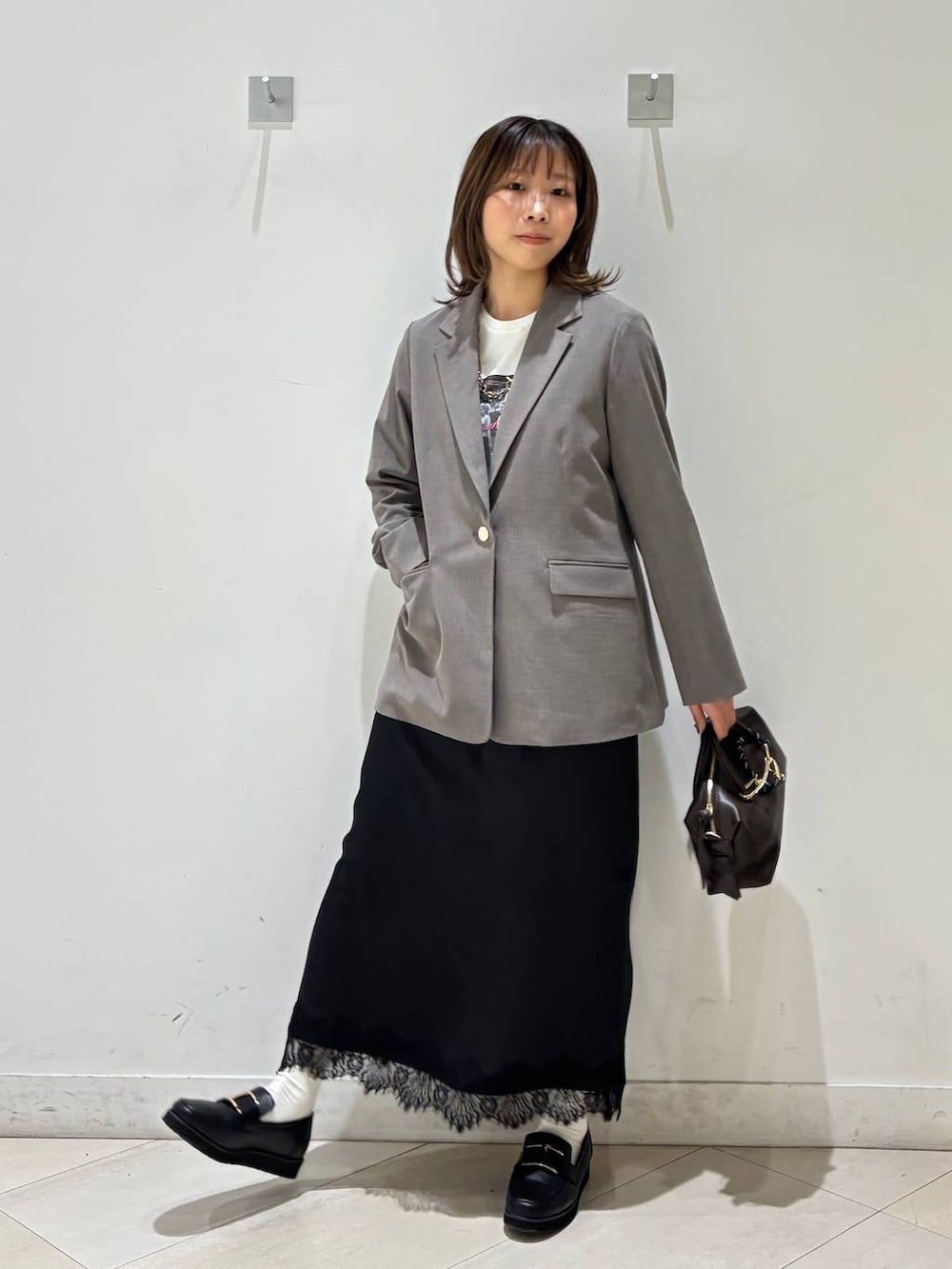 ブラック系のローファー、ブラウン系のテーラードジャケット、ブラウン系のボストンバッグを着用したレディースの春コーディネートの9枚目の写真