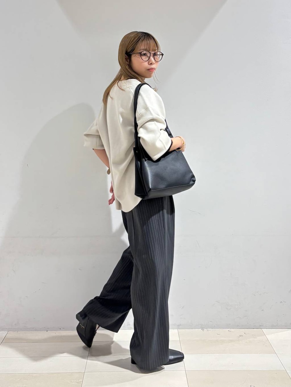 ブラック系のTシャツ/カットソー、グレー系のその他パンツ、ブラック系のトートバッグを着用したレディースの秋コーディネートの7枚目の写真