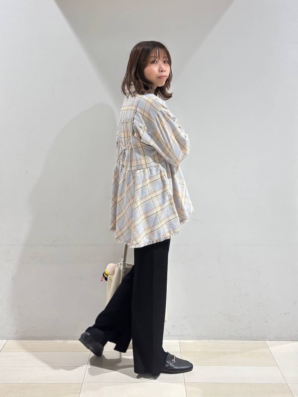 ブラック系のローファー、ホワイト系のハンドバッグ、ブラック系のその他パンツを着用したレディースの冬コーディネートの7枚目の写真