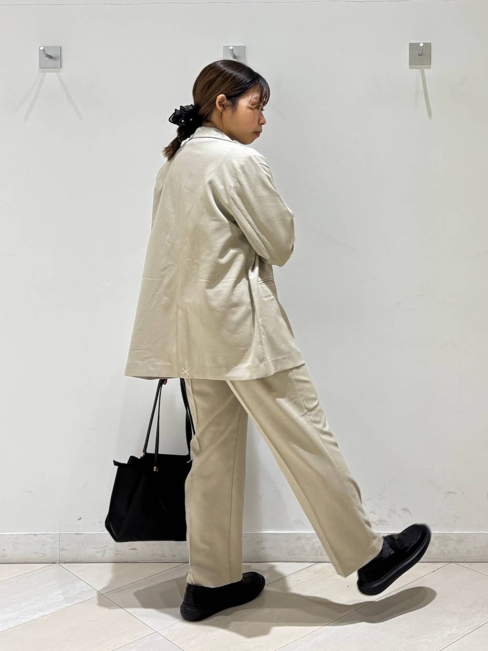 ベージュ系のその他パンツ、ベージュ系のテーラードジャケット、ブラック系のトートバッグを着用したレディースの春コーディネートの5枚目の写真