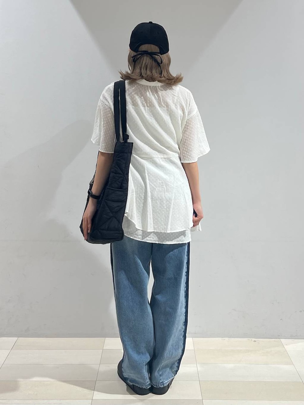 ブラック系のトートバッグ、ホワイト系のキャミソール、ブラック系のサンダルを着用したレディースの夏コーディネートの3枚目の写真