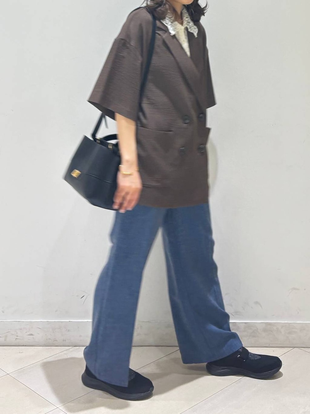 ブラック系のショルダーバッグ、ブルー系のその他パンツ、ブラウン系のテーラードジャケットを着用したレディースの春コーディネートの5枚目の写真