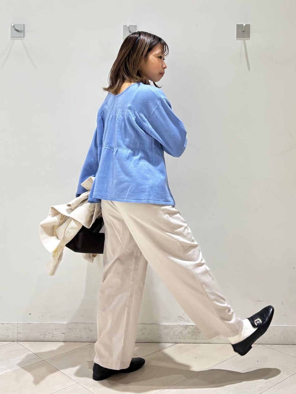 ブラック系のローファー、ホワイト系のその他パンツ、ブラウン系のボストンバッグを着用したレディースの春コーディネートの6枚目の写真