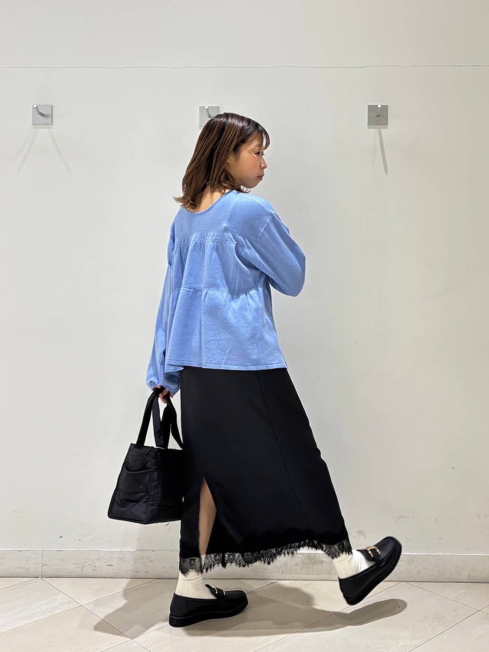 ブラック系のローファー、ブラック系のトートバッグ、ブルー系のカーディガン/ボレロを着用したレディースの春コーディネートの6枚目の写真