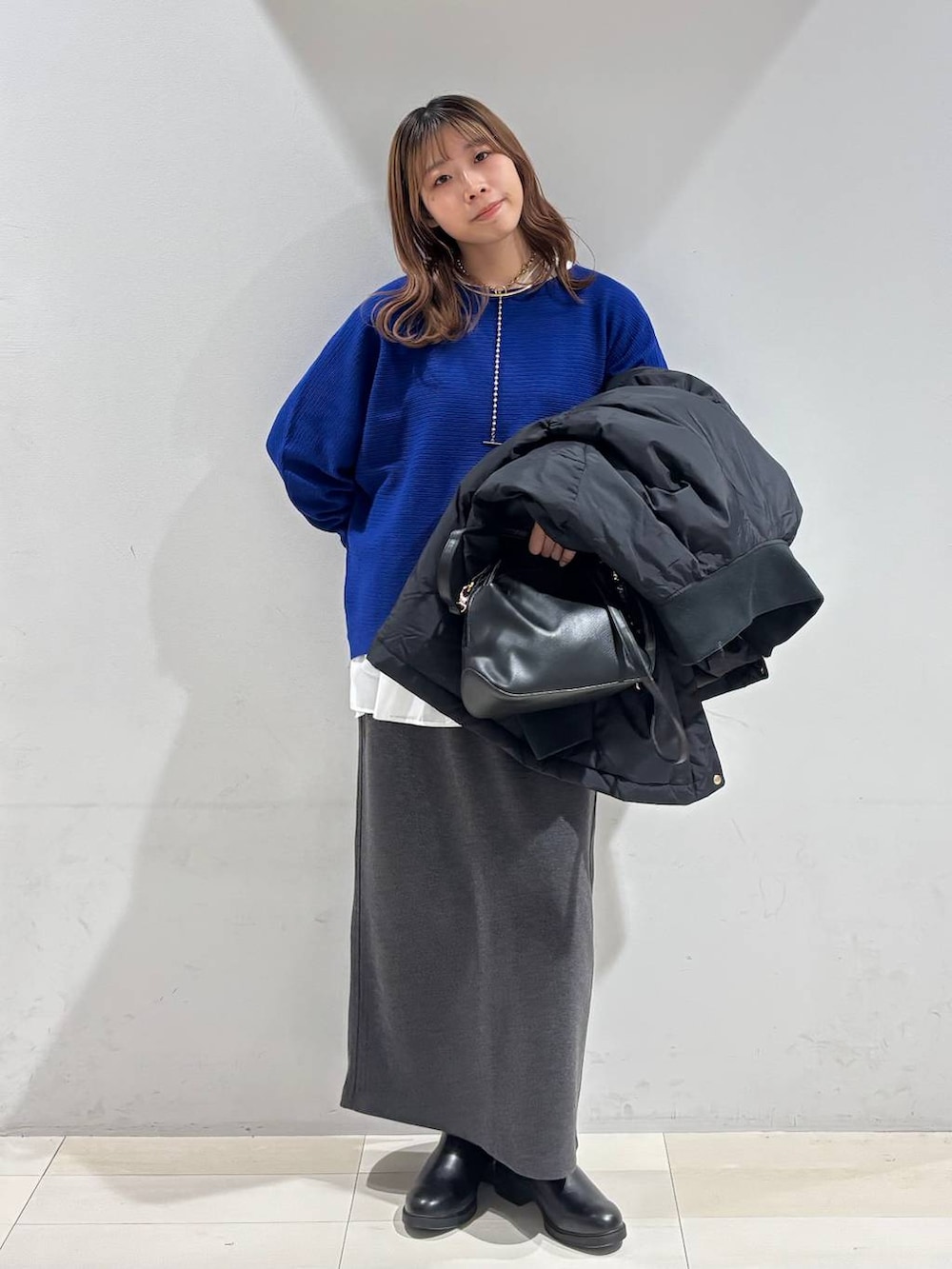 ブラック系のショルダーバッグ、ブラック系のダウンジャケット/コート、ホワイト系のTシャツ/カットソーを着用したレディースの冬コーディネートの5枚目の写真