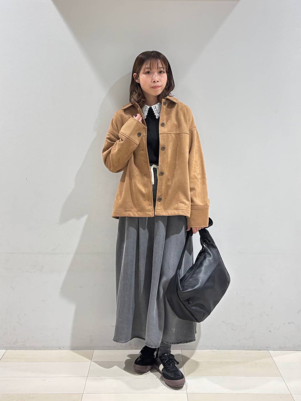 ブラック系のスニーカー、ブラック系のショルダーバッグ、ブラウン系のテーラードジャケットを着用したレディースの冬コーディネートの2枚目の写真