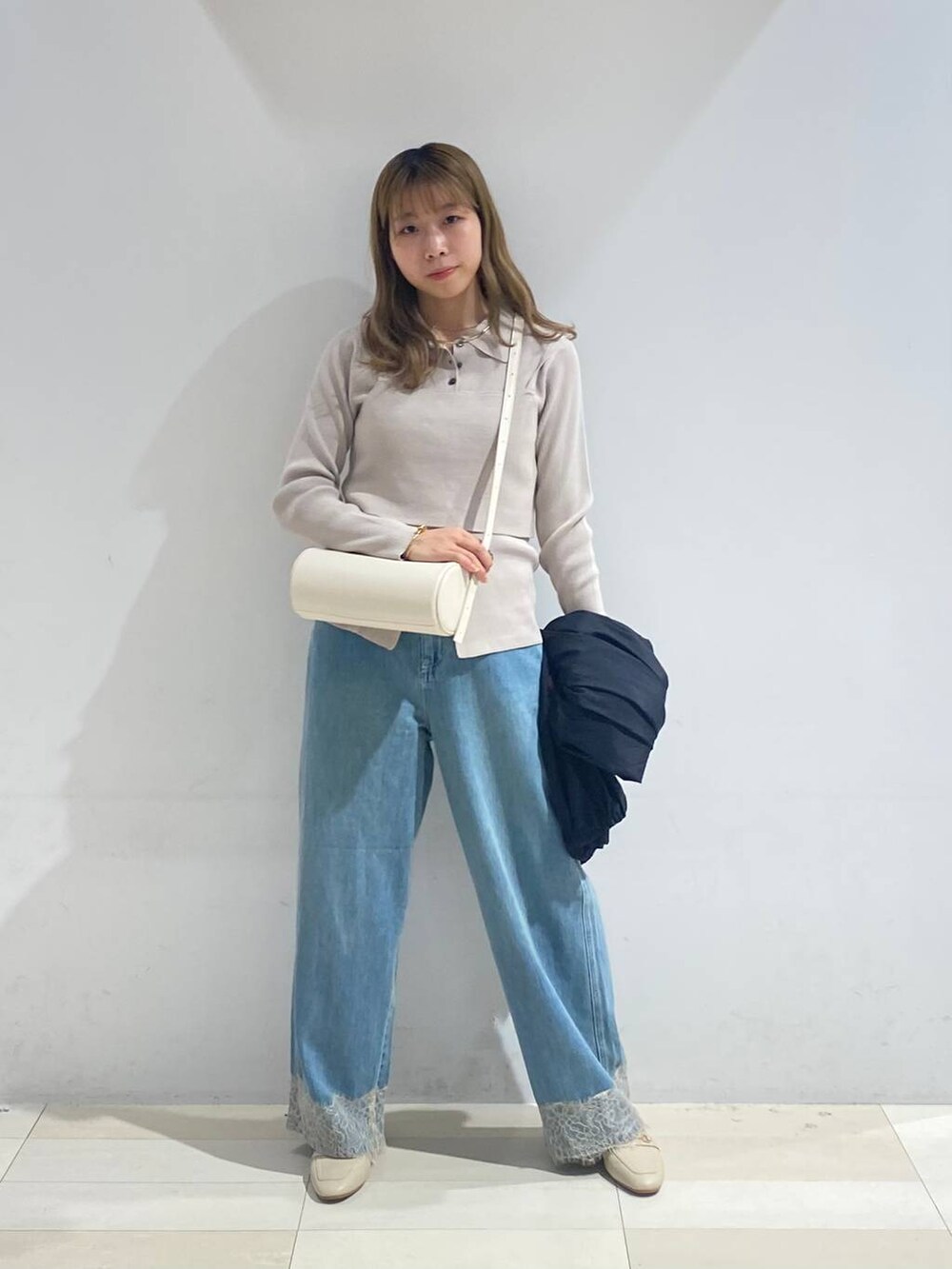 ベージュ系のTシャツ/カットソー、ホワイト系のクラッチバッグ、ホワイト系のローファーを着用したレディースの秋コーディネートの2枚目の写真