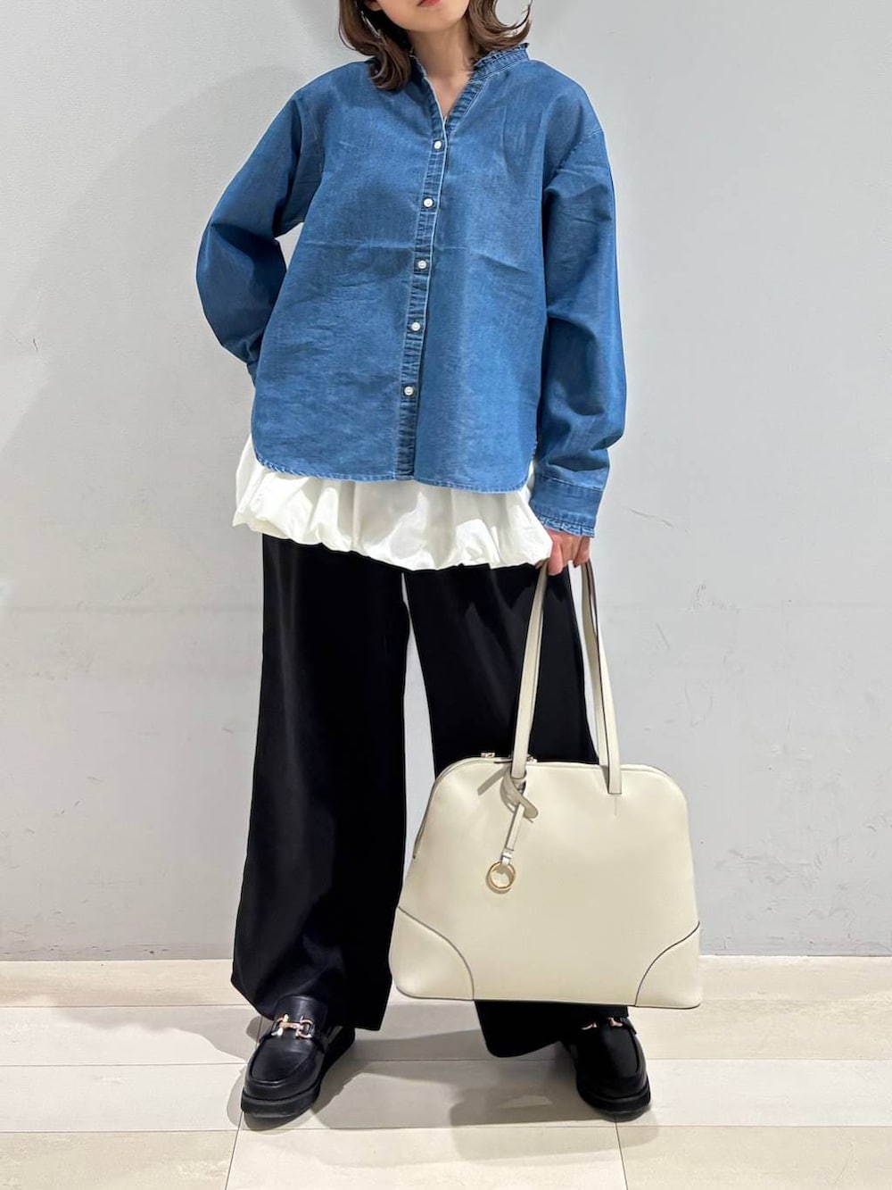 ブラック系のローファー、ベージュ系のボストンバッグ、ブルー系のシャツ/ブラウスを着用したレディースの春コーディネートの8枚目の写真