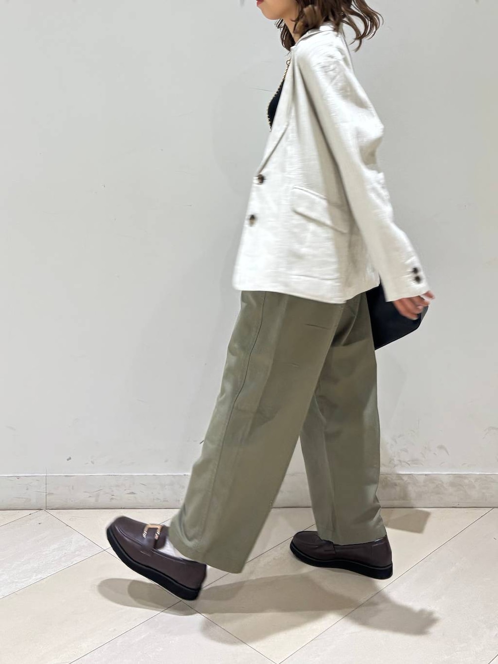 ブラック系のショルダーバッグ、ブラウン系のローファー、ブラック系のキャミソールを着用したレディースの春コーディネートの7枚目の写真