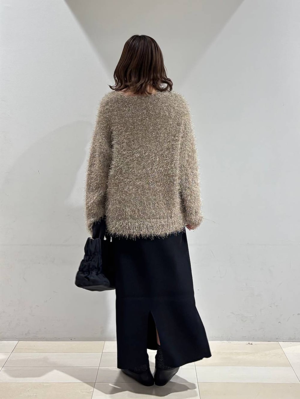 ブラック系のバレエシューズ、ブラック系のトートバッグ、ブラック系のスカートを着用したレディースの春コーディネートの4枚目の写真