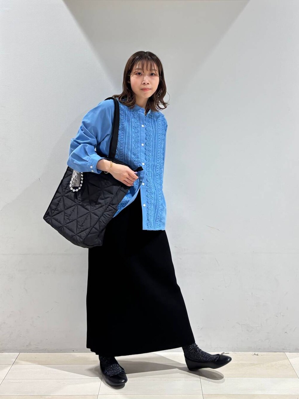 ブラック系のバレエシューズ、ブラック系のトートバッグ、ブラック系のスカートを着用したレディースの冬コーディネートの3枚目の写真