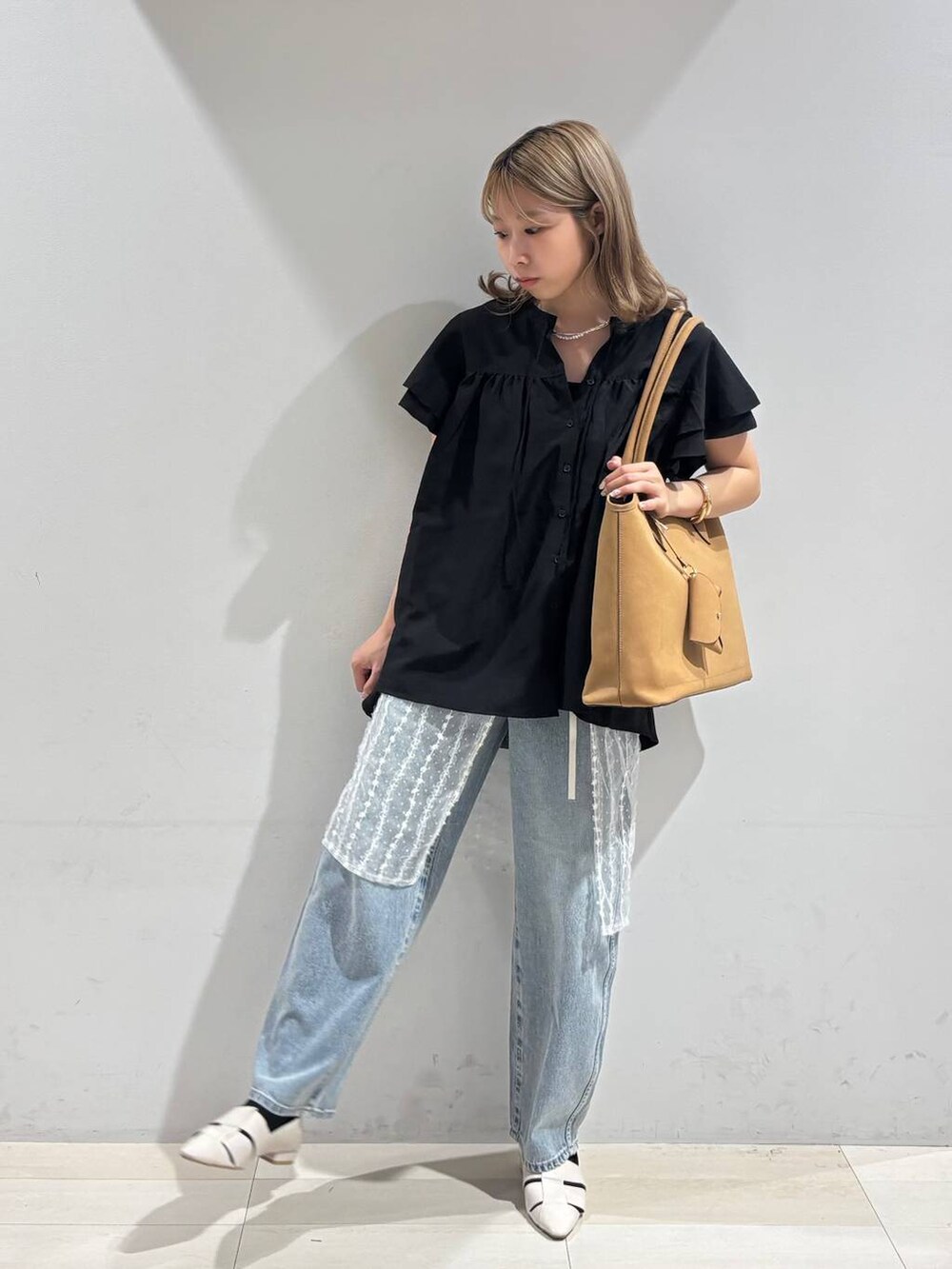 ブルー系のデニムパンツ、ホワイト系のパンプス、ベージュ系のトートバッグを着用したレディースの夏コーディネートの6枚目の写真