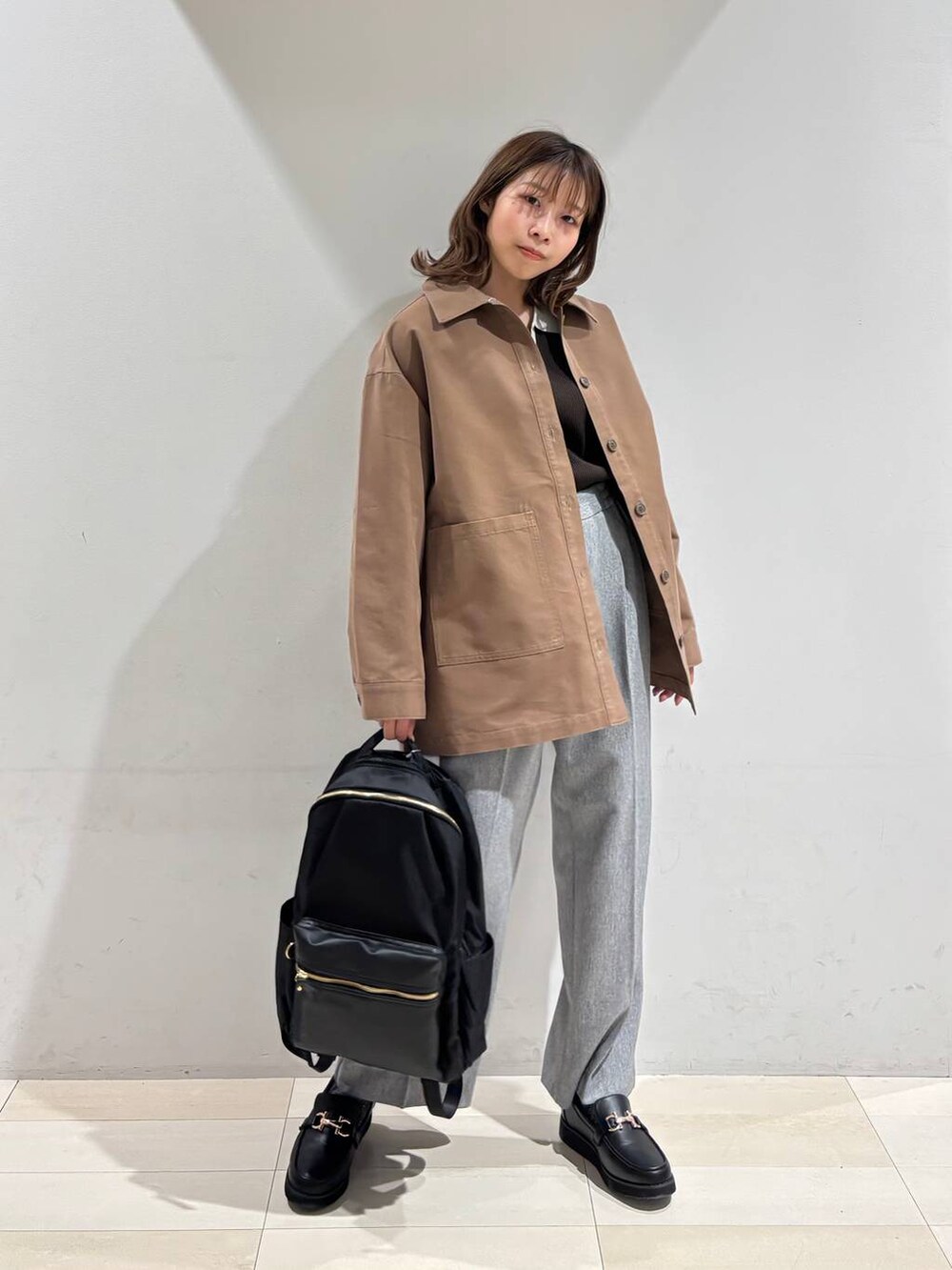 ブラック系のローファー、ブラック系のバックパック/リュック、グレー系のその他パンツを着用したレディースの春コーディネートの9枚目の写真