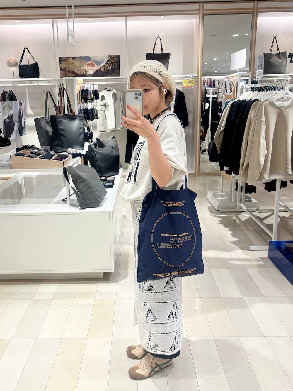 ブルー系のデニムパンツ、グレー系のTシャツ/カットソー、ゴールド系のネックレスを着用したレディースの秋コーディネートの2枚目の写真