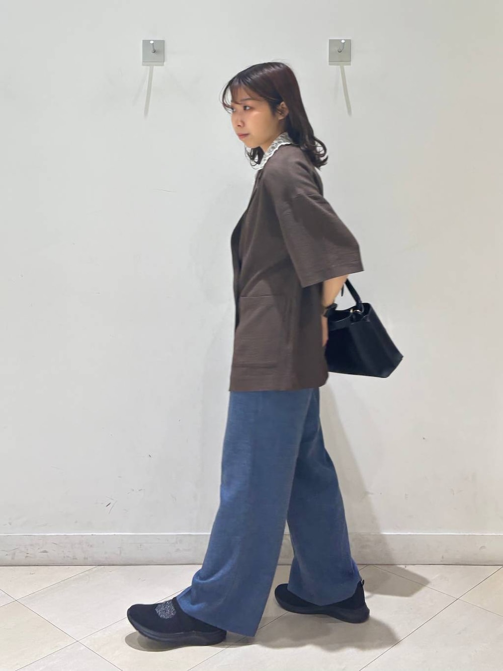 ブラック系のショルダーバッグ、ブルー系のその他パンツ、ブラウン系のテーラードジャケットを着用したレディースの春コーディネートの9枚目の写真