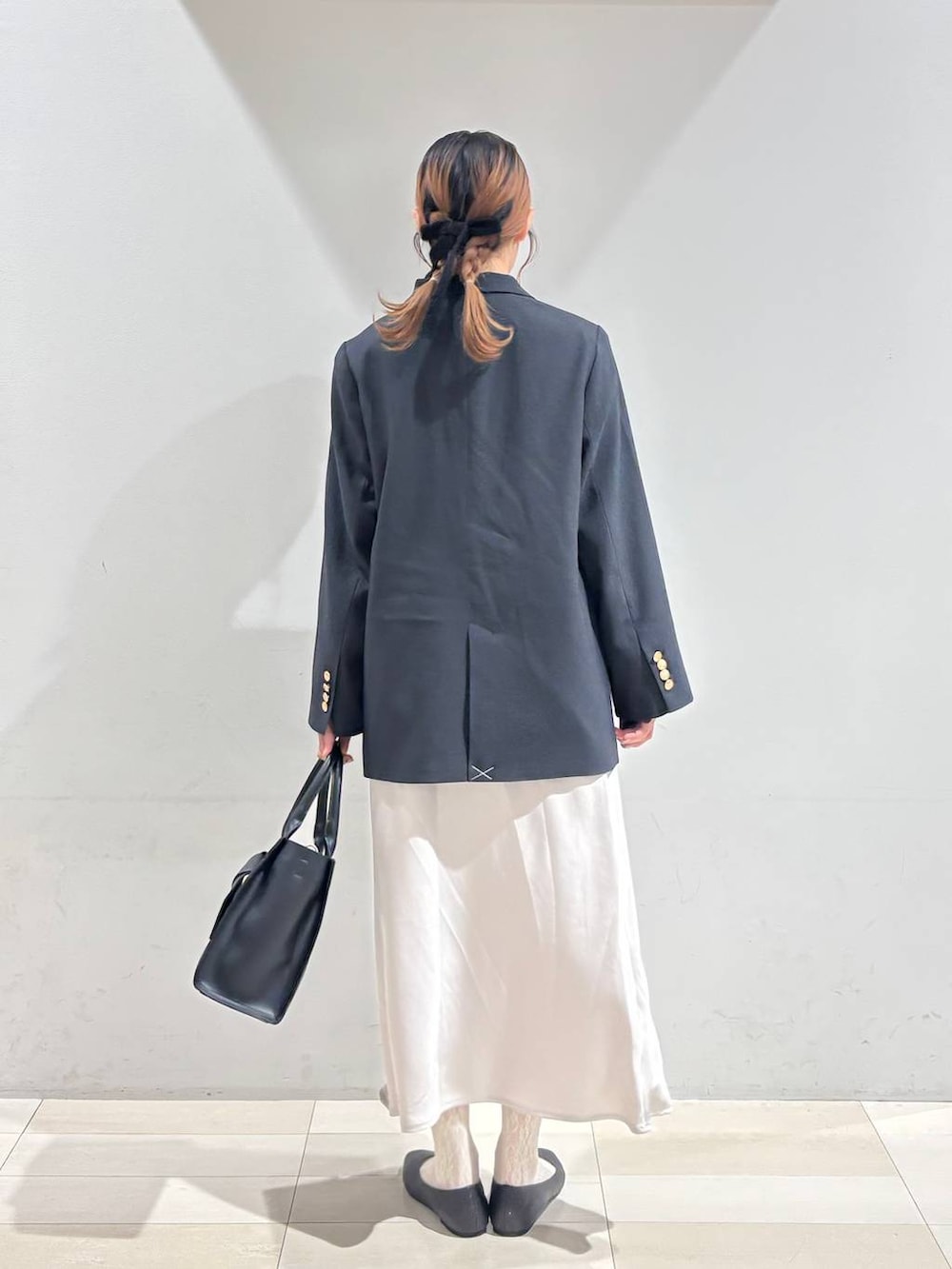 ブラック系のパンプス、ブラック系のシャツ/ブラウス、ブラック系のハンドバッグを着用したレディースの冬コーディネートの5枚目の写真