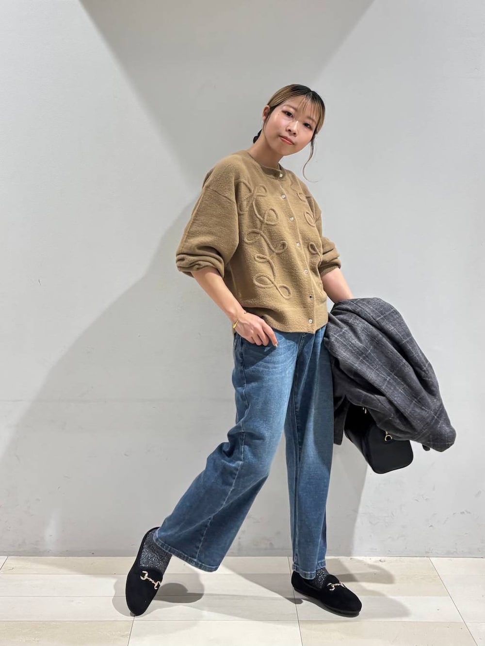 その他のチェスターコート、イエロー系のカーディガン/ボレロ、ブルー系のデニムパンツを着用したレディースの秋コーディネートの9枚目の写真