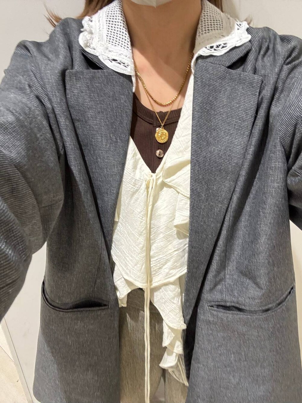 ベージュ系のその他パンツ、グレー系のテーラードジャケット、ブラウン系のタンクトップを着用したレディースの春コーディネートの9枚目の写真