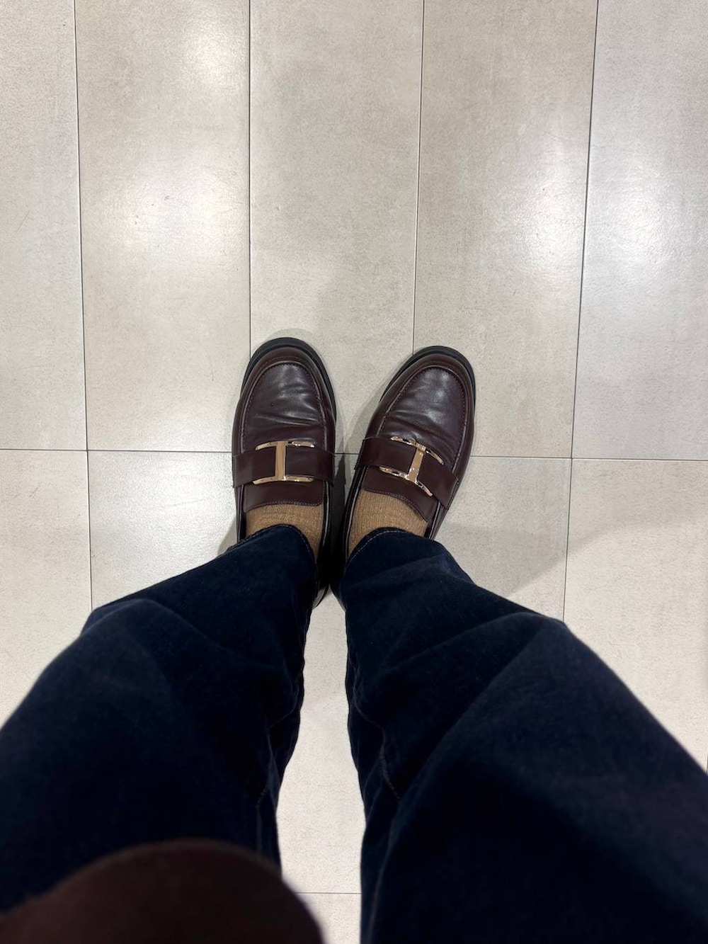 ブラウン系のローファー、ブルー系のデニムパンツ、ブラウン系のカーディガン/ボレロを着用したレディースの秋コーディネートの7枚目の写真