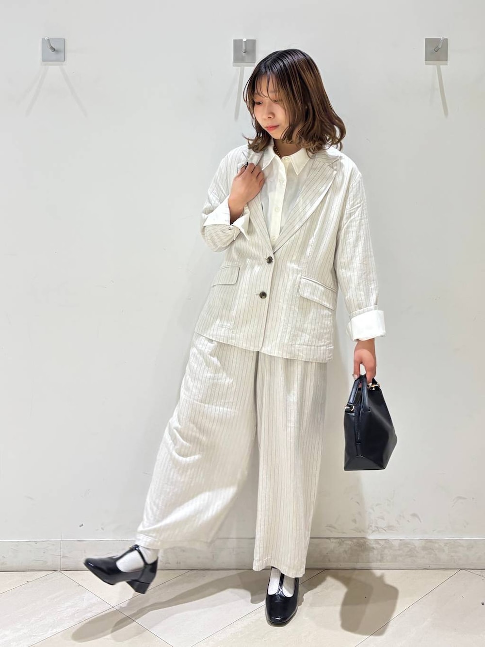 ブラック系のショルダーバッグ、ベージュ系のその他パンツ、グレー系のテーラードジャケットを着用したレディースの春コーディネートの9枚目の写真