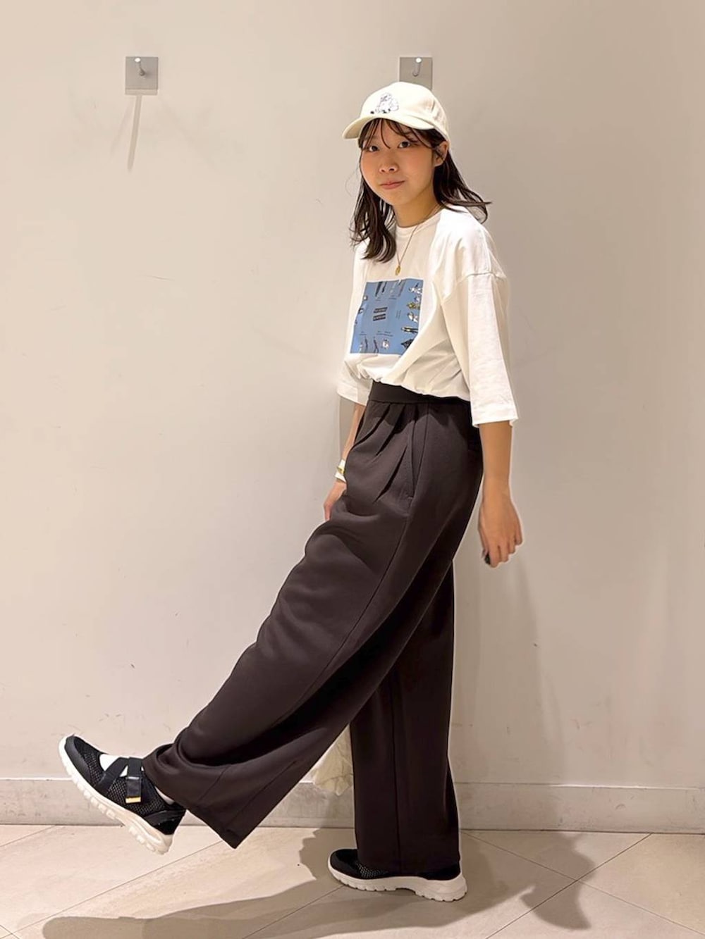 ブラック系のスニーカー、ブラウン系のその他パンツ、ホワイト系のエコバッグ/サブバッグを着用したレディースの春コーディネートの5枚目の写真