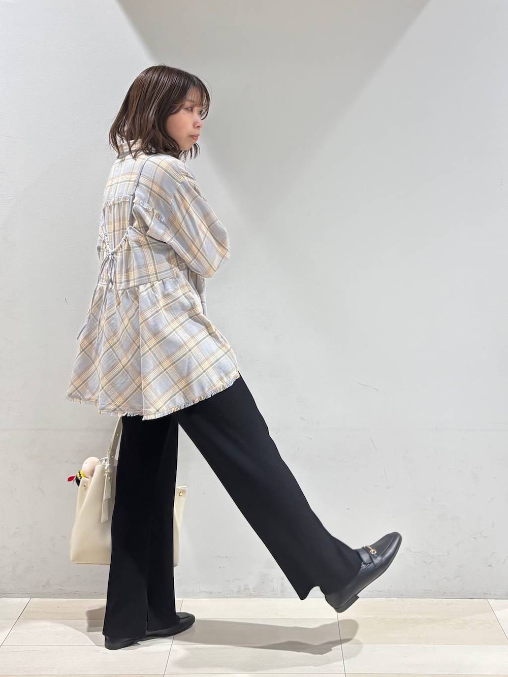 ブラック系のローファー、ホワイト系のハンドバッグ、ブラック系のその他パンツを着用したレディースの冬コーディネートの6枚目の写真