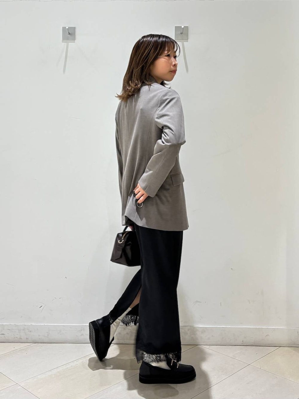 ブラック系のローファー、ブラウン系のテーラードジャケット、ブラウン系のボストンバッグを着用したレディースの春コーディネートの6枚目の写真