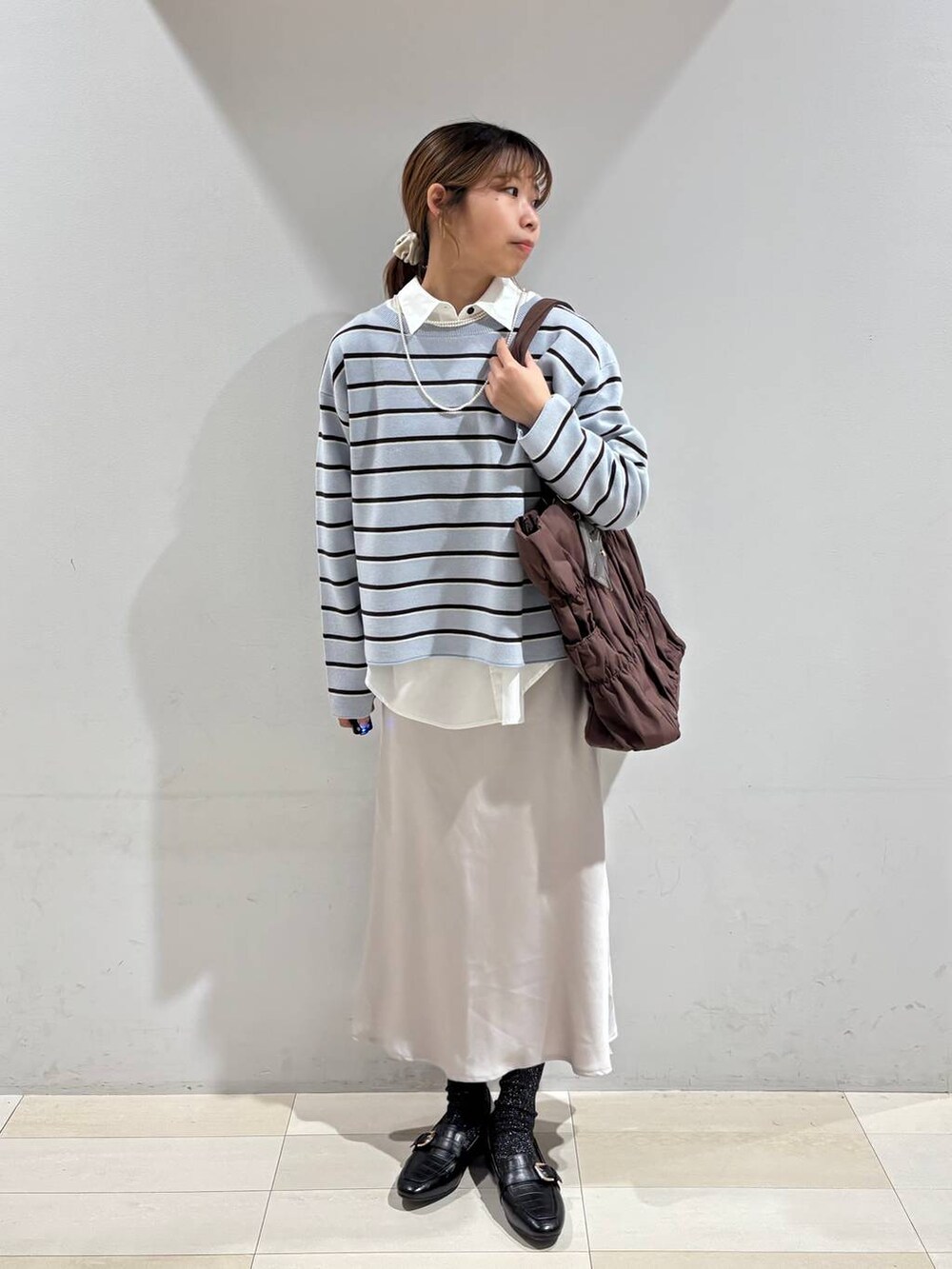 ブラック系のローファー、ブラウン系のトートバッグ、ブルー系のニット/セーターを着用したレディースの冬コーディネートの9枚目の写真