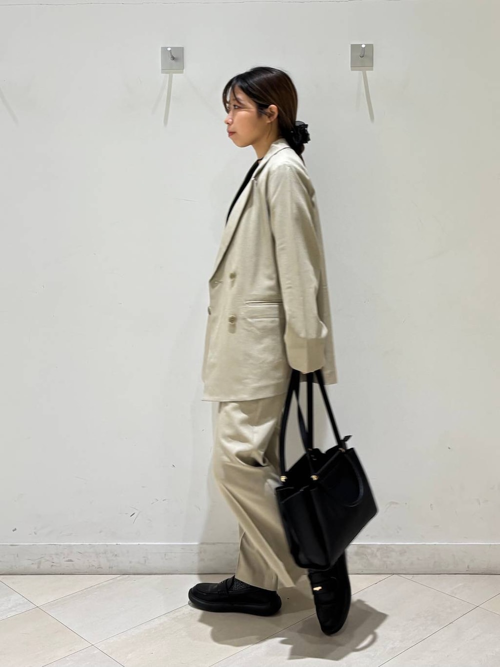 ベージュ系のその他パンツ、ベージュ系のテーラードジャケット、ブラック系のトートバッグを着用したレディースの春コーディネートの3枚目の写真