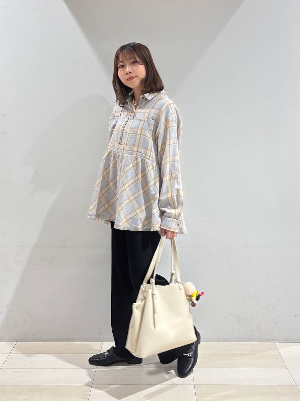 ブラック系のローファー、ホワイト系のハンドバッグ、ブラック系のその他パンツを着用したレディースの冬コーディネートの4枚目の写真