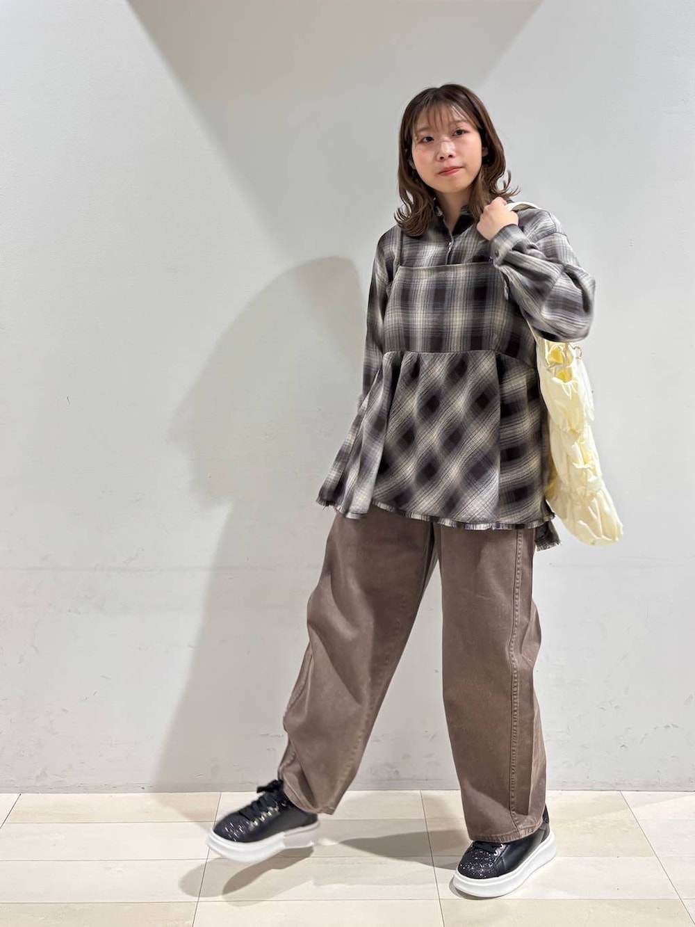 ベージュ系のトートバッグ、ブラウン系のデニムパンツ、ブラウン系のシャツ/ブラウスを着用したレディースの春コーディネートの3枚目の写真